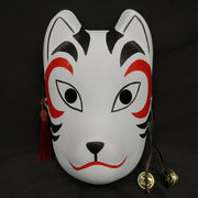 A hand-painted Kitsune (fox) mask with a strap, designed to resemble a cat's face with curved markings.